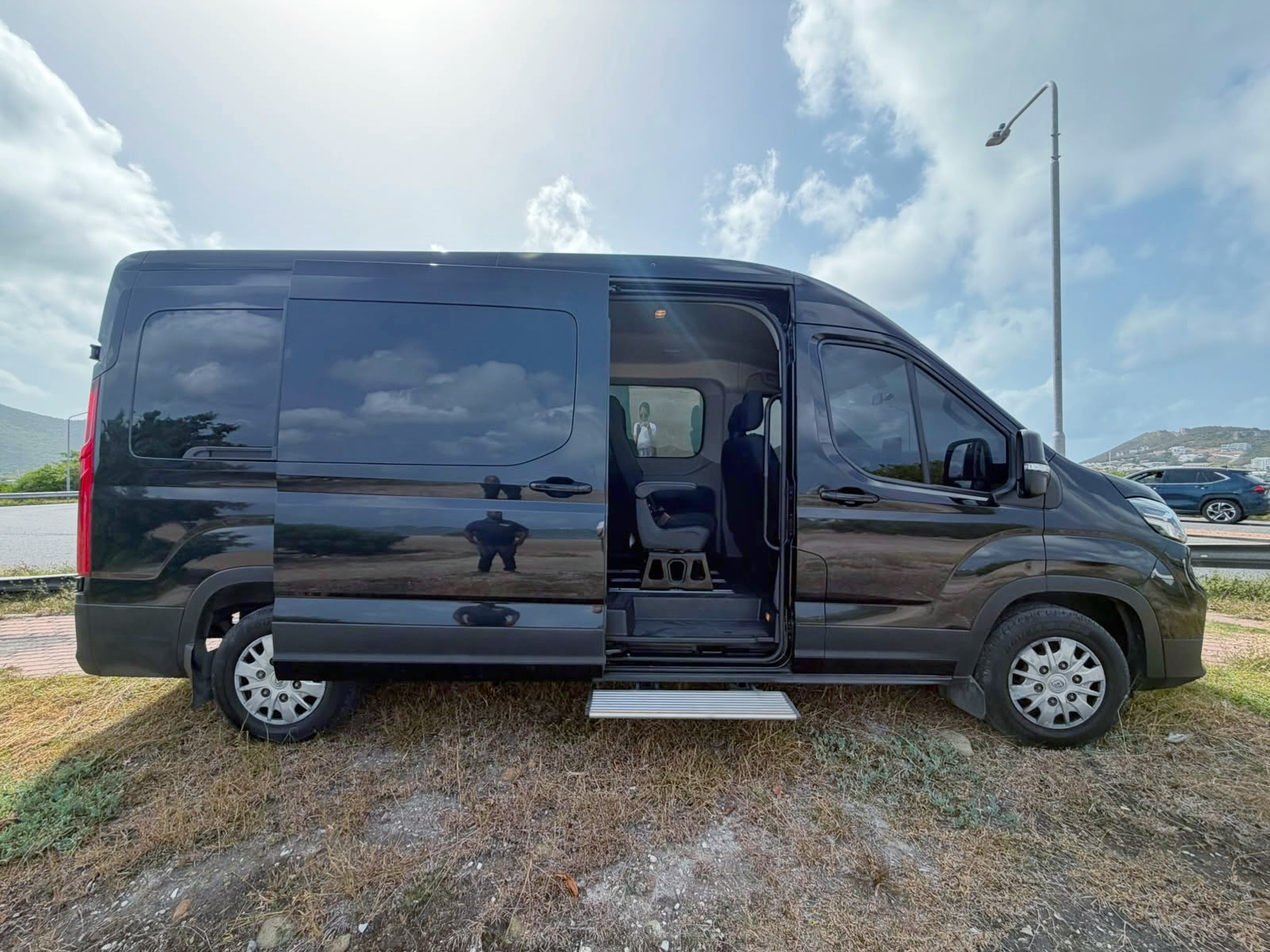 Black Johnson Fantastic Transport van parked beside a luxury superyacht at the Sint Maarten marina
