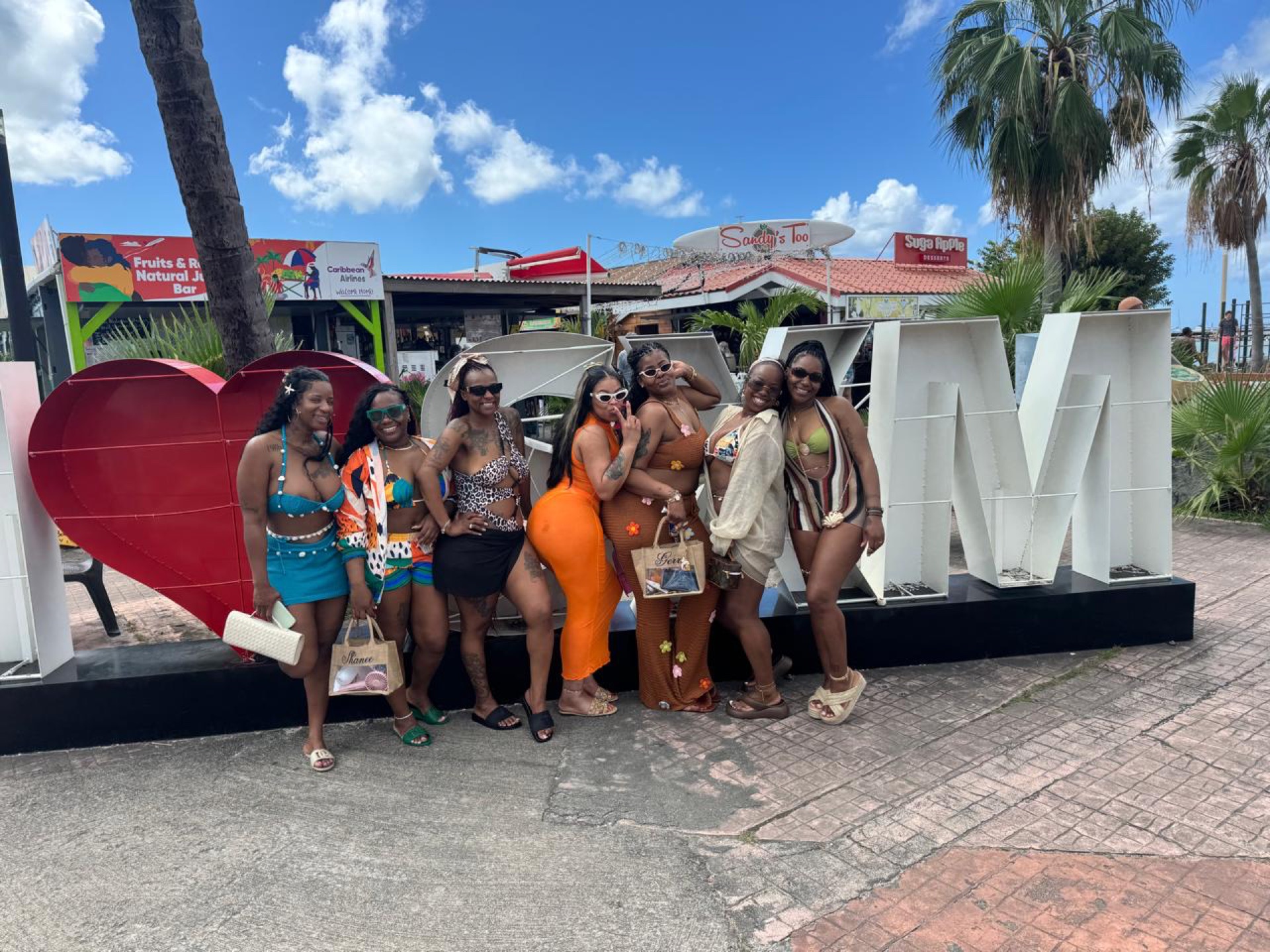 Stylish group posing at the I love SXM sign in Marigot, Sint Maarten