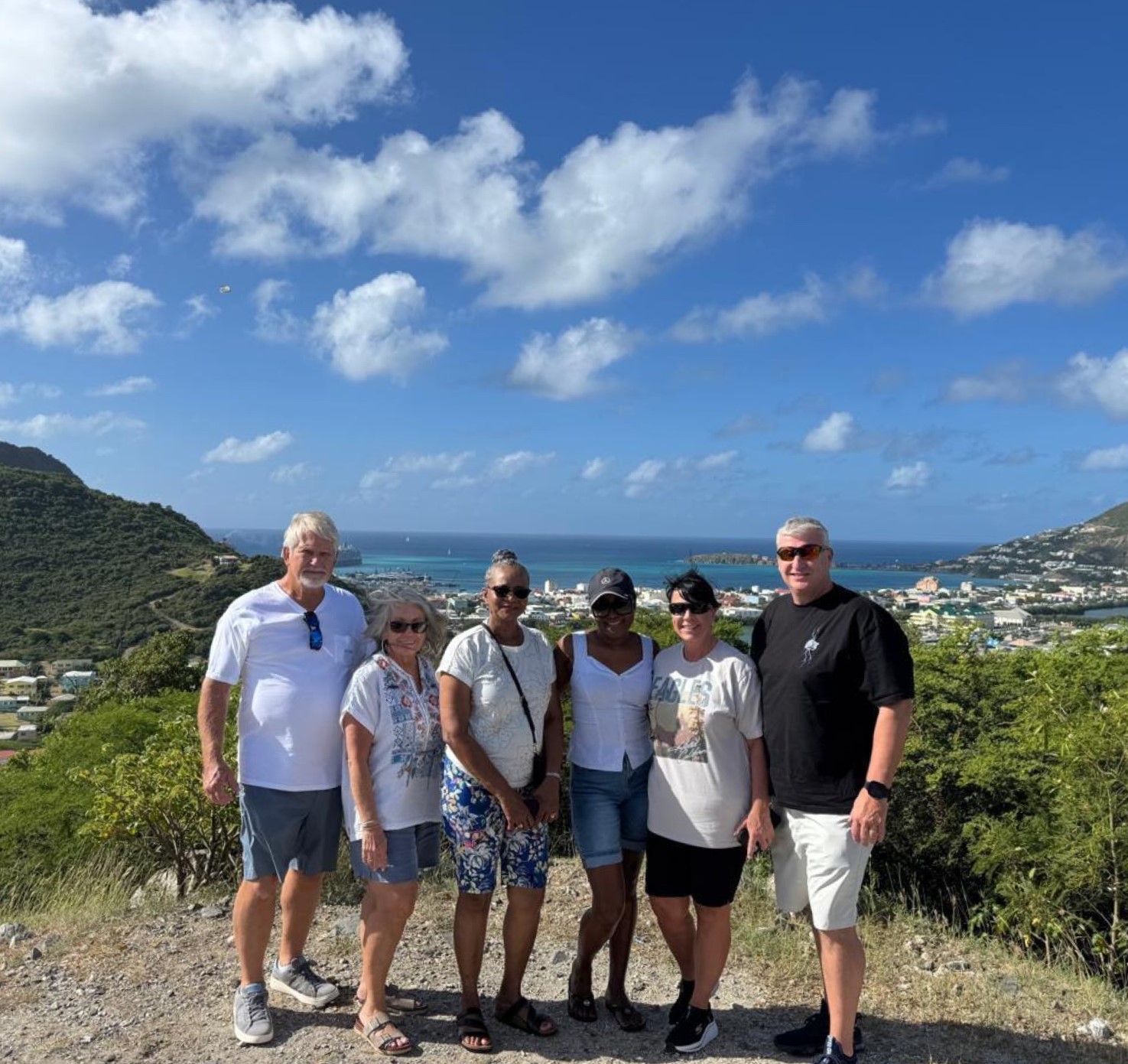 Happy tour group at a hilltop viewpoint overlooking Simpson Bay on a Sint Maarten island tour