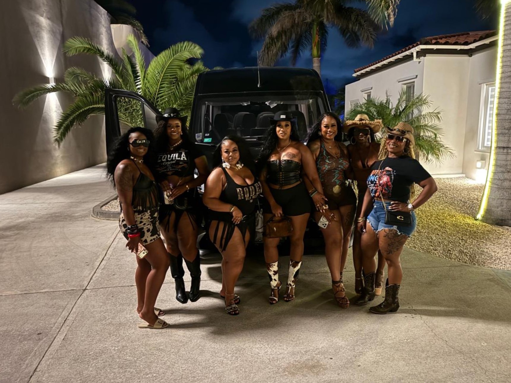 Guests in front of a luxury black van outside a villa at night in Sint Maarten